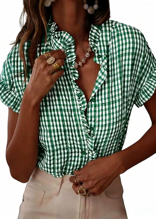 Green and white checkered blouse worn by a person on a white background
