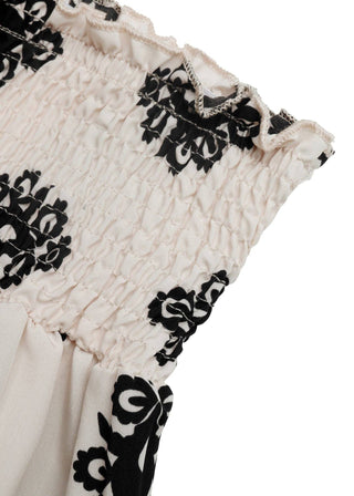 Close-up of a garment with black floral patterns on a white background