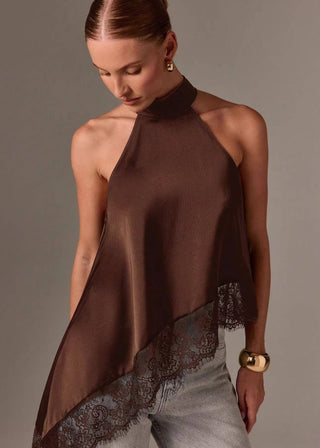 Woman wearing a brown halter top with lace details on a plain background