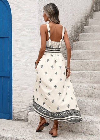 Woman in a white patterned dress standing on stone steps with a blue door in the background