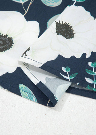 Close-up of floral fabric with white flowers and green leaves on a navy background