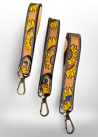 Two leather straps with sunflower designs on a light gray background