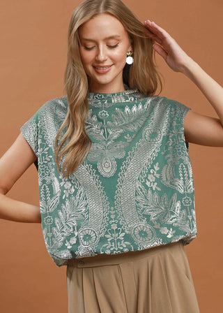 Woman wearing a green patterned top against a brown background