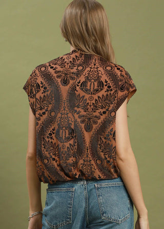 Woman wearing a patterned top with a green background