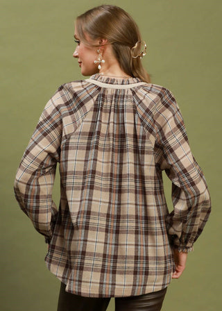 Woman wearing a plaid shirt with a green background