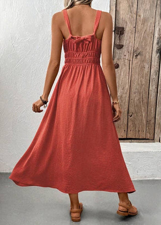 Woman wearing a red dress standing in front of a wooden door.