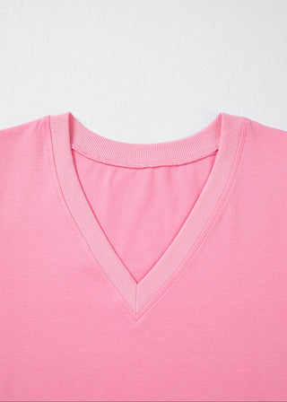 Close-up of a pink V-neck shirt on a light gray background
