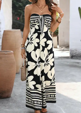 Woman wearing a black and white floral strapless jumpsuit outdoors.