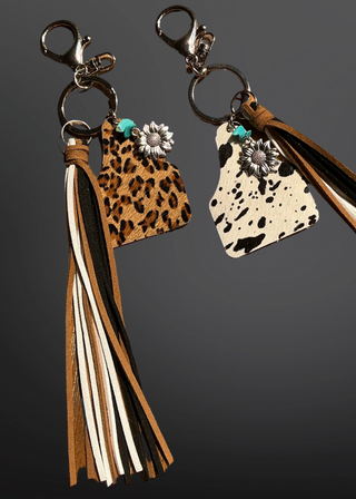 Two keychains with tassels on a dark background