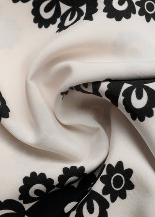 Close-up of white fabric with black floral patterns