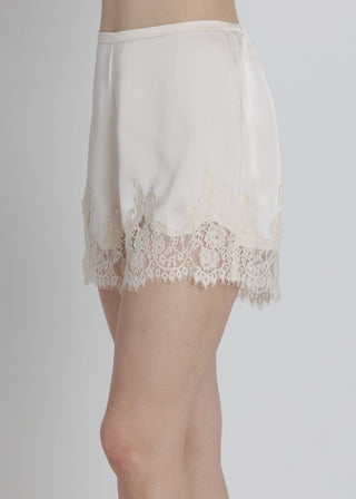 White lace-trimmed satin nightgown on a plain background