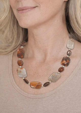 Necklace with large jasper brown and beige beads worn by a person