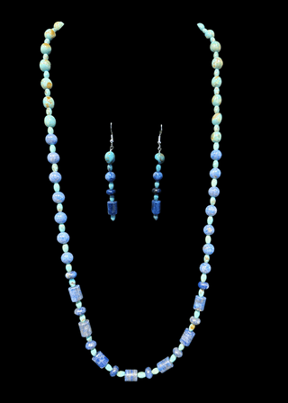 Necklace and earrings set with turquoise and lapis beads on a black background