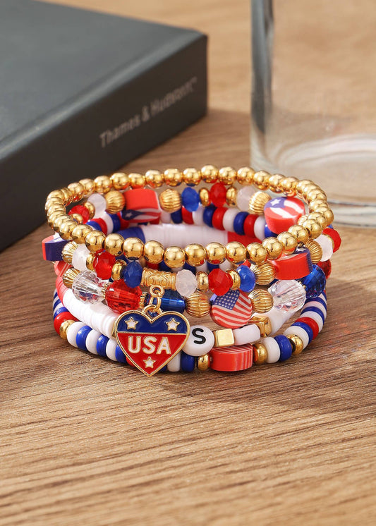 Stack of colorful beaded bracelets with USA-themed charms on a wooden surface