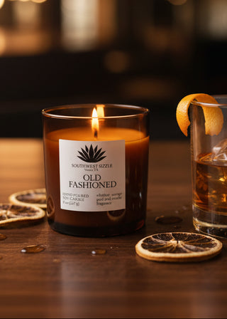 Old Fashioned soy candle on bar top with an old fashioned cocktail
