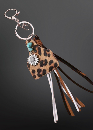 Leopard print keychain with tassels on a dark background