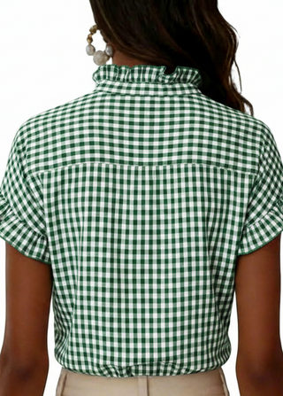 Green and white checkered blouse worn by a person on a white background