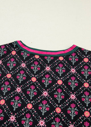 Floral patterned fabric with pink and green trim on a white background
