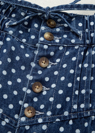 Close-up of a blue denim shirt with white polka dots and wooden buttons.