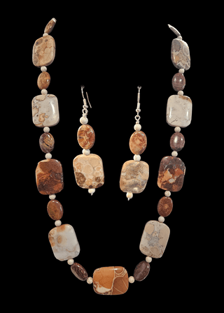 Jewelry set with necklace and earrings featuring brown and white jasper stones on a black background
