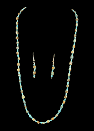 Necklace and earrings set with turquoise beads on a black background
