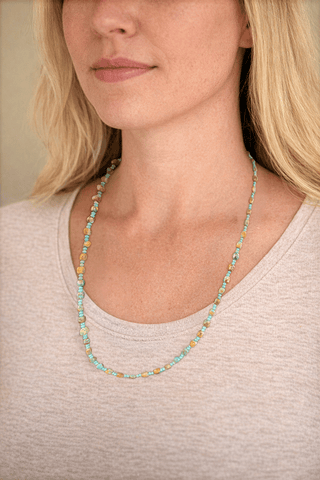 Close-up of a woman wearing a Turquoise necklace with a neutral background